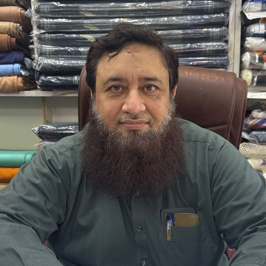 The proprietor of Shahzad Cloth House at the shop counter, Kashmiri Mohalla, Sialkot