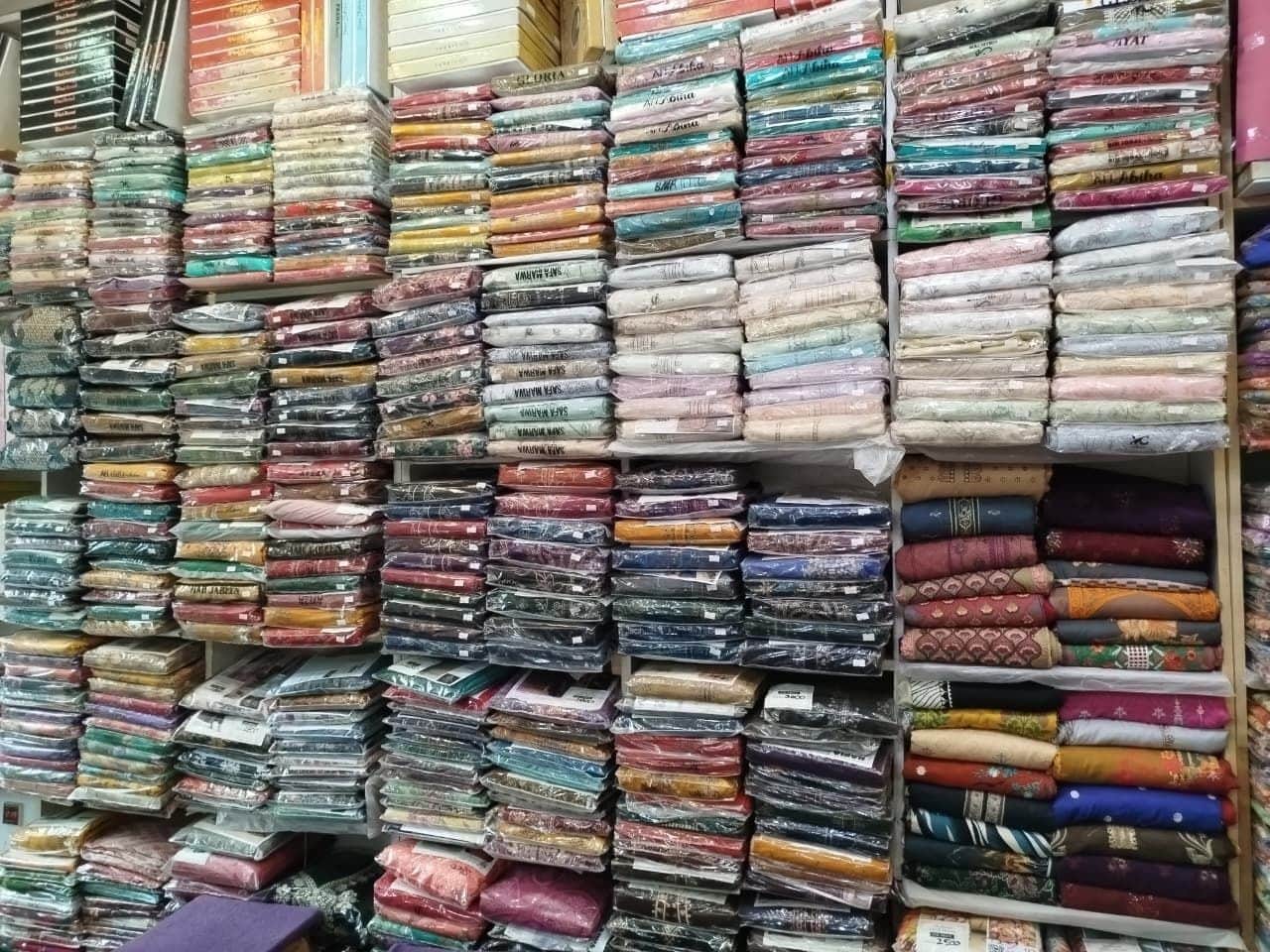 A wall of packed printed lawn suits at Shahzad Cloth House